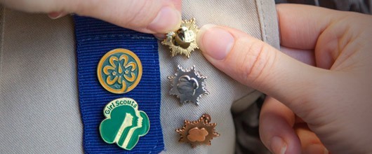 19_Marcomm_HighestAwardsPage_homepagehero_530x220 Girl Scout being pinned with a Gold Award