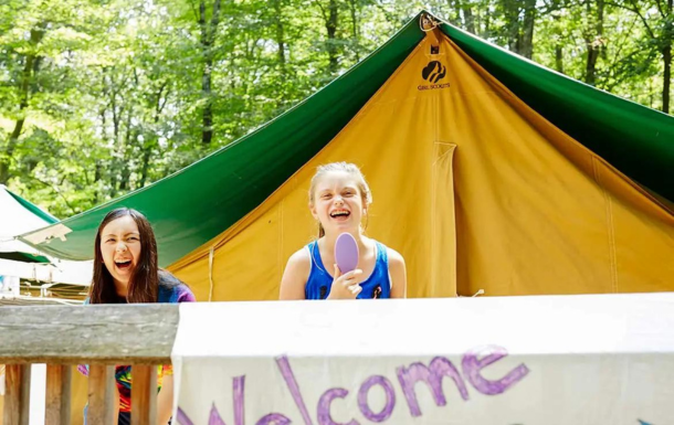 Two Girl Scouts outside of a tent.