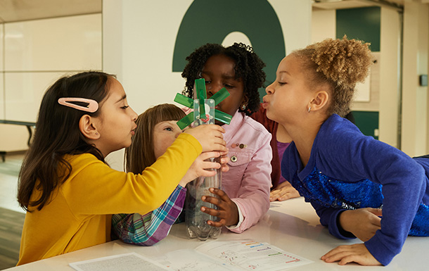 Four young girls working together to build a model windmill.