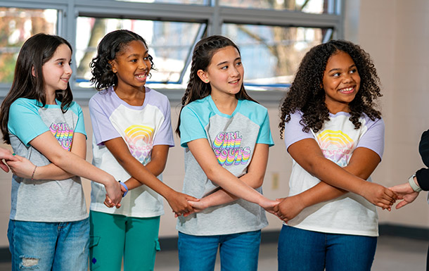 Four girls holding hands in a friendship circle
