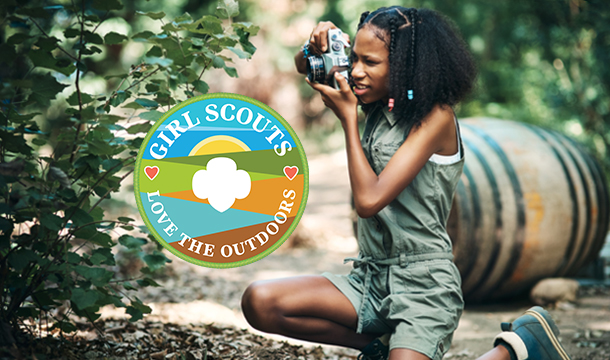 Girl holding a camera and taking a photo of nature