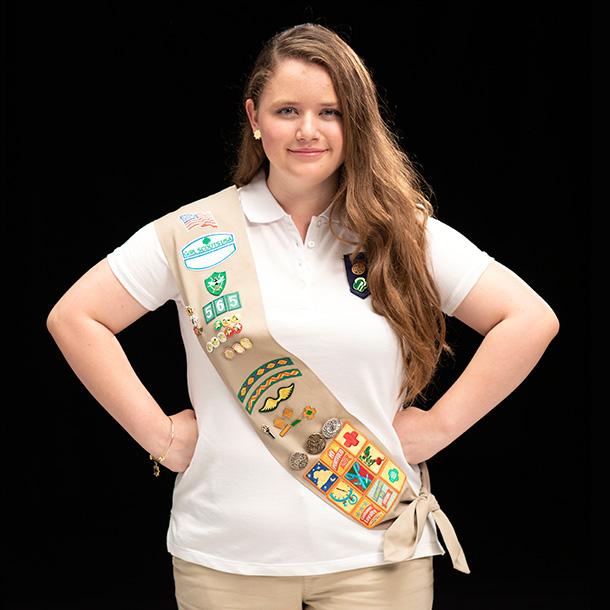 gold award girl scout wearing ambassador sash and pin