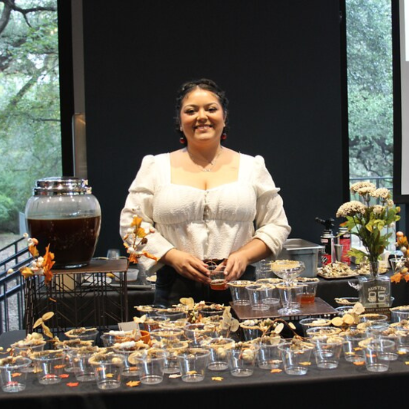 Woman smiling in front of drinks